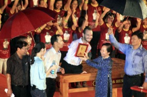 Đại biểu quốc hội Nguyễn Thị Doan  đội ô lên tặng ảnh Bác Hồ cho Nick ở sân VĐ Mỹ Đình khi trời đang mưa.(23/5/2013)